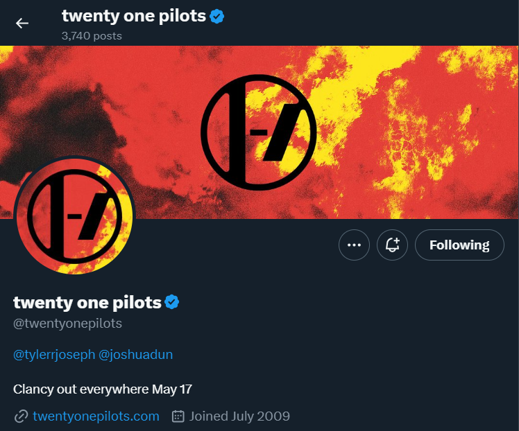 Alt text: Twenty one pilots&#39; twitter profile with new profile picture and header. Red and yellow background with new band logo featured on both the profile picture and header.